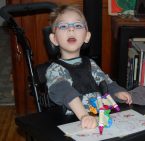 Youung-boy-coloring-in-wheel-chair-body-braces[2]